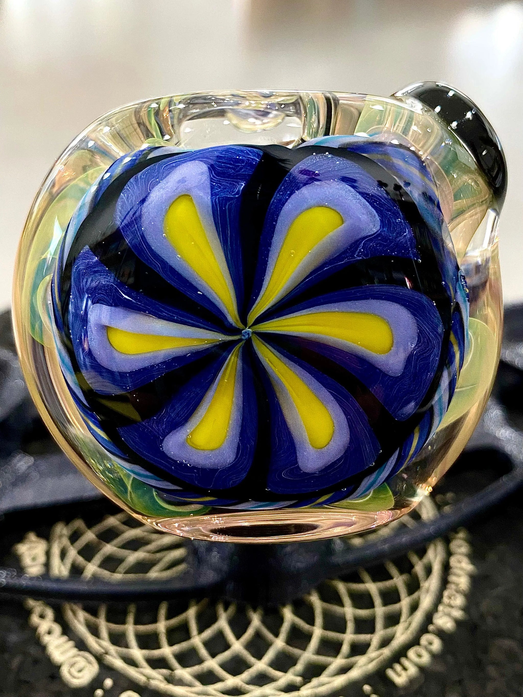 Colorful flower-designed glass spoon pipe by Talent Glass Works Inc, showcasing intricate glass art and vibrant colors.